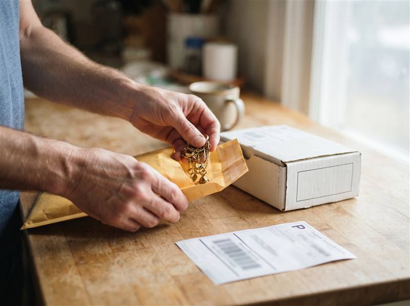 Packing gold jewelry into a free insured shipping kit at home